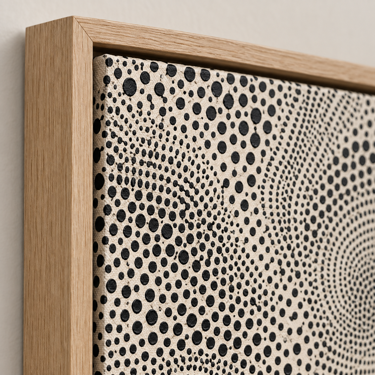 Close-up detail of black dotted texture, canvas weave and natural oak floater frame