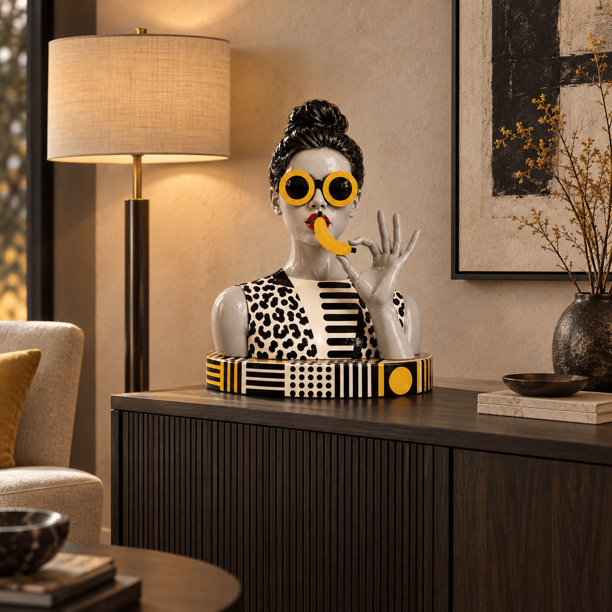 Banana sculpture styled on a console table beside a floor lamp – Banana Woman by Rossetti Art