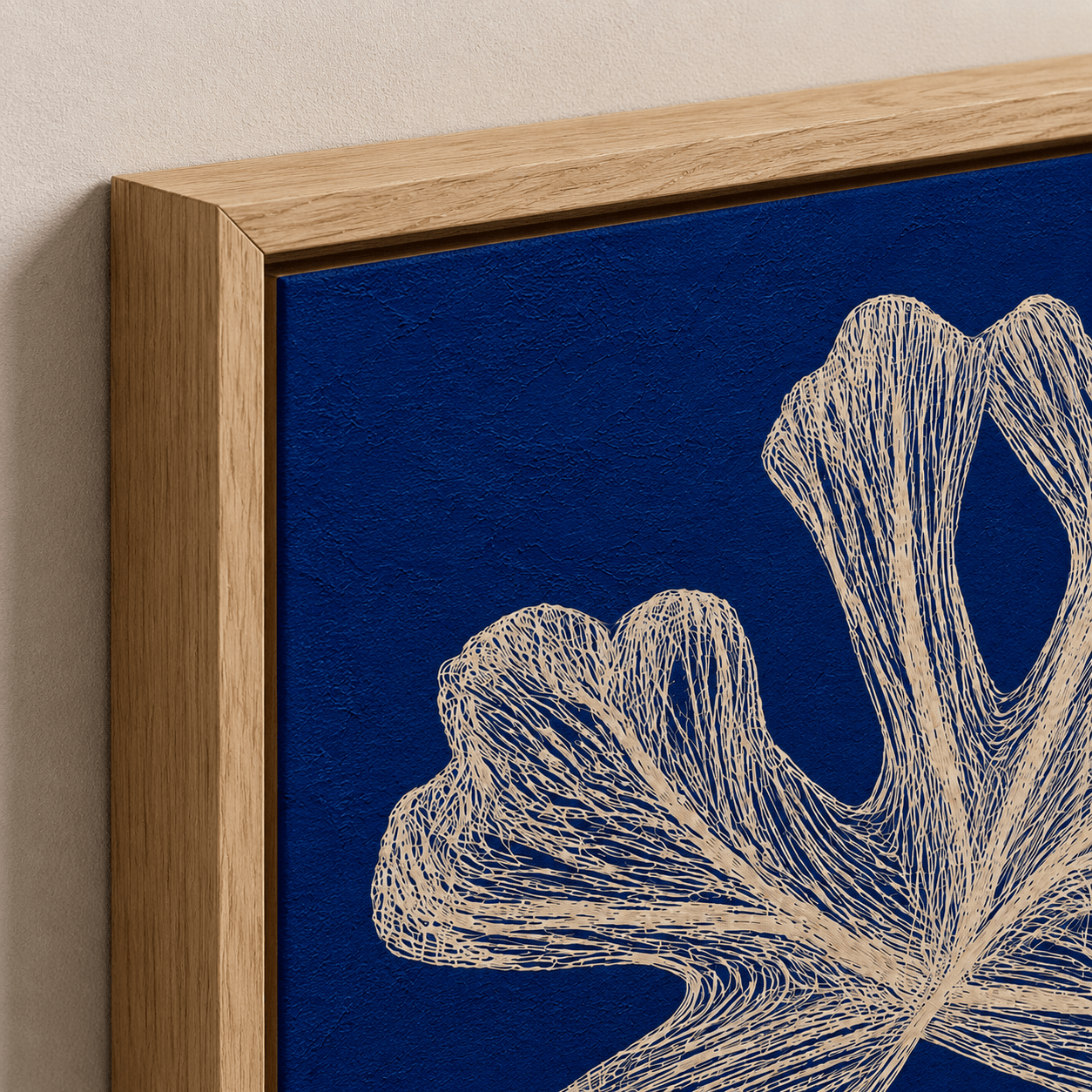 Close-up of blue botanical wall art canvas showing fine line coral detail and hardwood floater frame