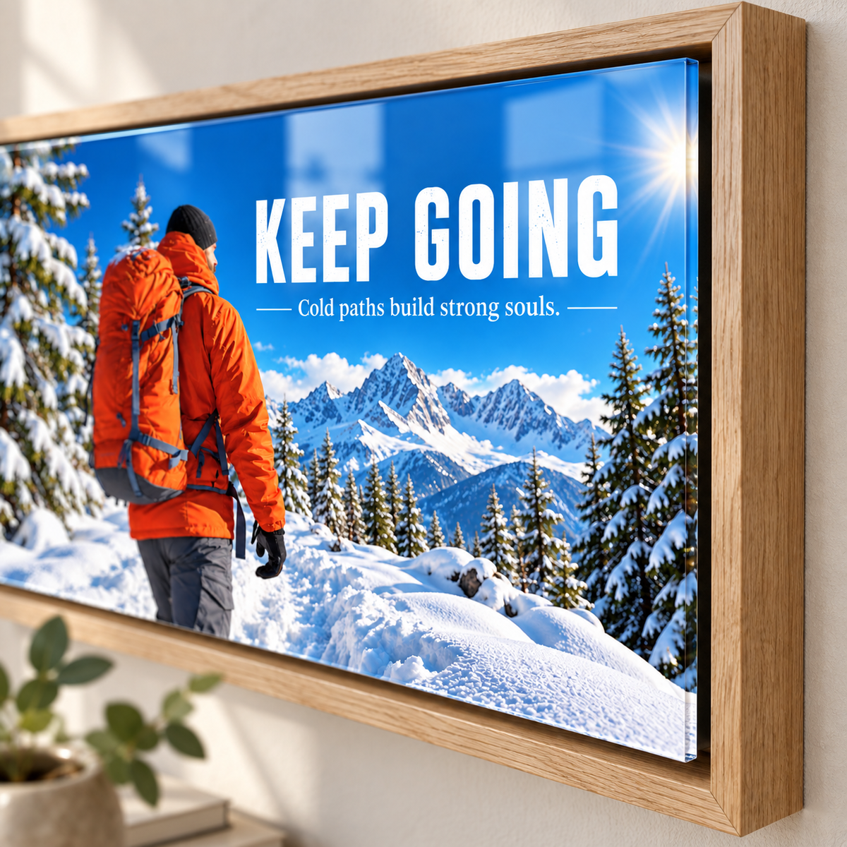 Close-up of mountain wall art – Keep Going high-gloss acrylic print in an oak frame showing the snowy alpine scene by Rossetti Art
