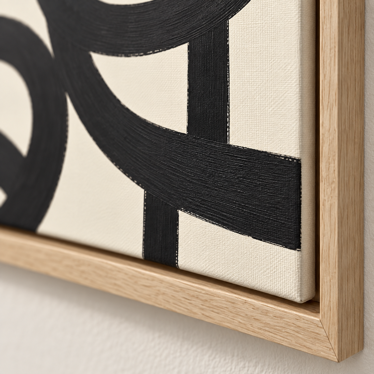 Close-up of black brushwork, canvas texture and oak floating frame