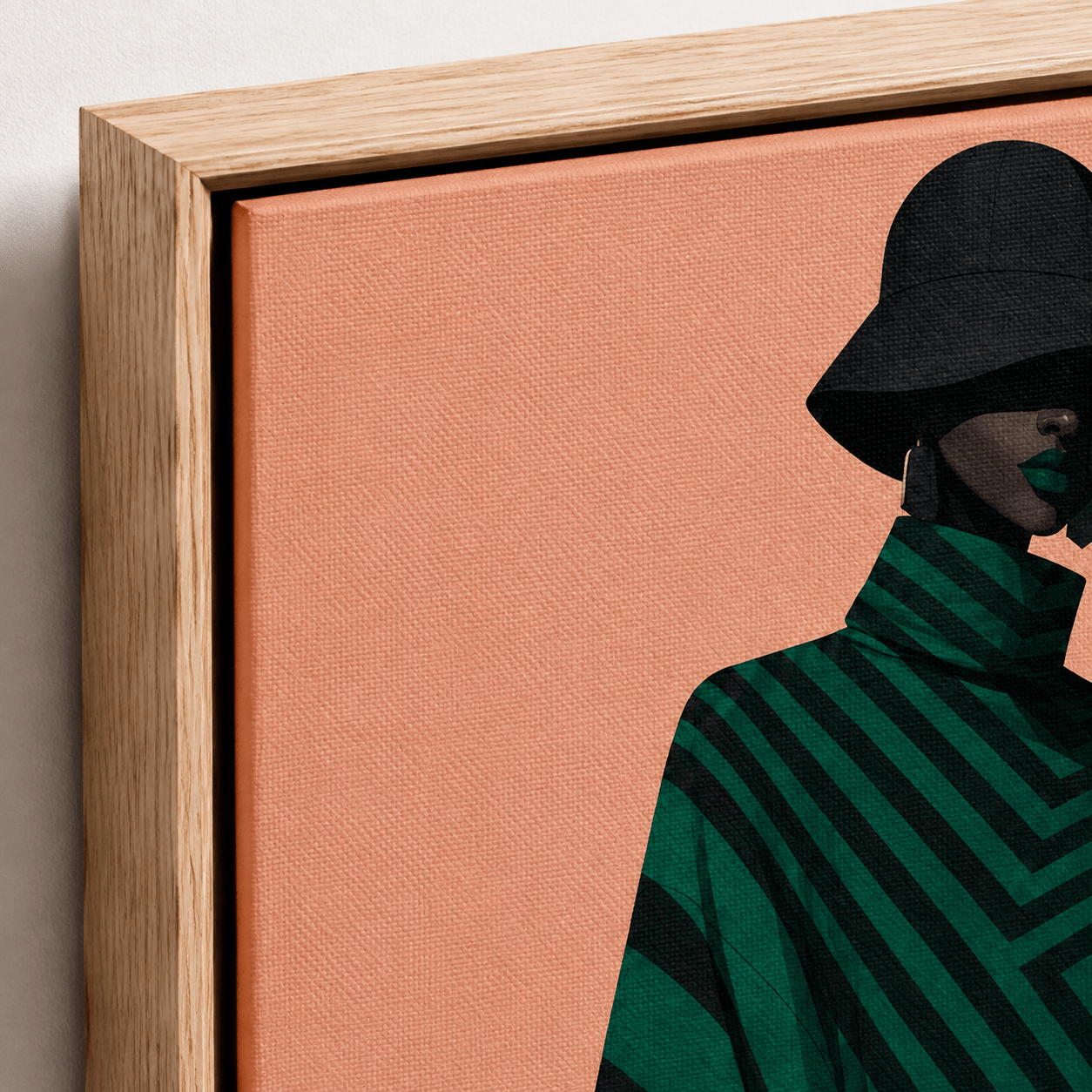 Close-up detail of the emerald and black chevron canvas print in an oak floater frame